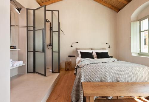 a bedroom with a bed and a wooden floor at Ruga of Vamvakou Homes in Vamvakoú