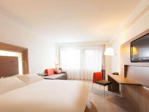 a hotel room with a bed and a television at Novotel Metz Centre in Metz