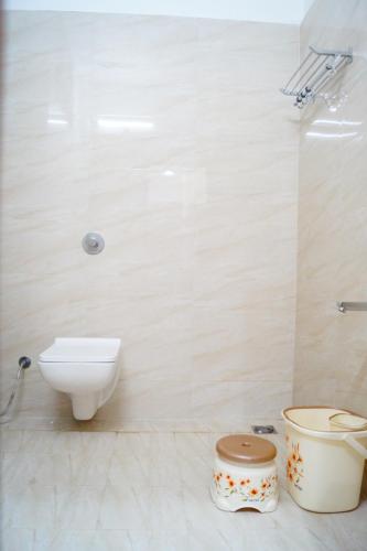 a white bathroom with a toilet and a sink at Hotel Shree Shyam International in Bilāspur
