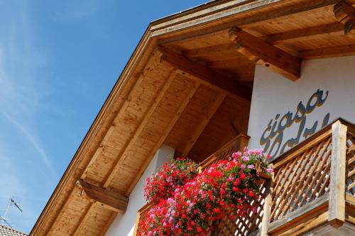 a building with a balcony with flowers on it at Ciasa Roby in San Cassiano