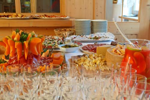 a table with many plates of food and wine glasses at Ciasa Roby in San Cassiano