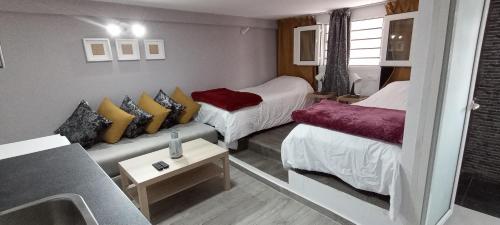 Habitación pequeña con 2 camas y lavamanos en Studios Taha en Rabat