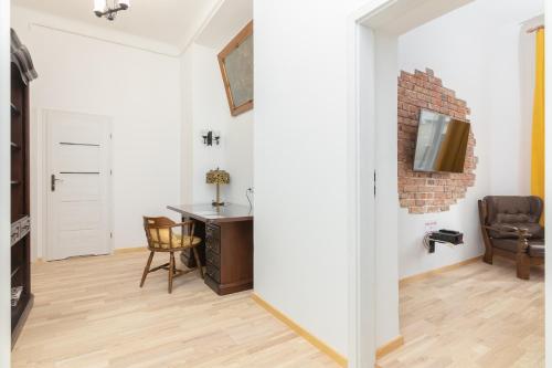 een woonkamer met een bureau en een bakstenen muur bij Metro Politechnika Vintage Apartment in Warschau