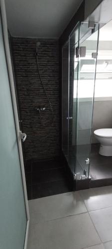 a bathroom with a glass shower and a toilet at Studios Taha in Rabat