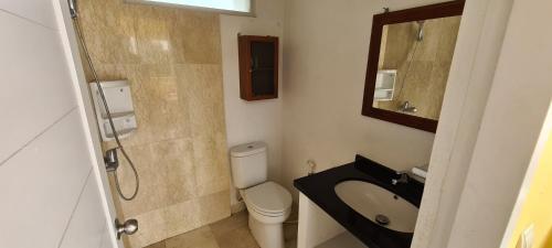 uma casa de banho com um WC, um lavatório e um espelho. em Villa Marbelice em Bandung
