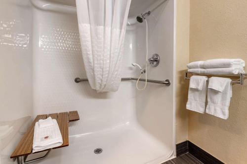 a bathroom with a tub and a shower with towels at Comfort Inn Shelbyville North in Shelbyville