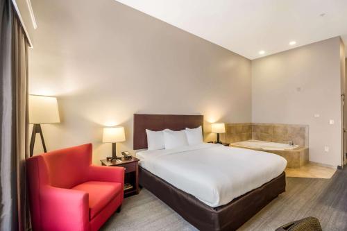 a bedroom with a bed and a chair and a tub at Comfort Inn & Suites Fairburn - Atlanta Southwest in Fairburn