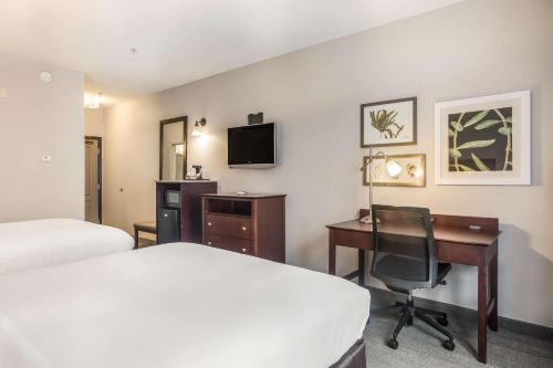 a hotel room with a bed and a desk and a computer at Comfort Inn & Suites Fairburn - Atlanta Southwest in Fairburn