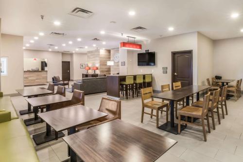 a restaurant with tables and chairs and a bar at Comfort Inn & Suites Fairburn - Atlanta Southwest in Fairburn