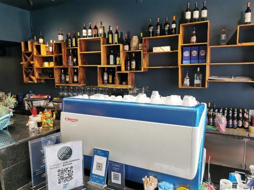 a bar with a counter with bottles of alcohol at Invito Guesthouse in Sihanoukville