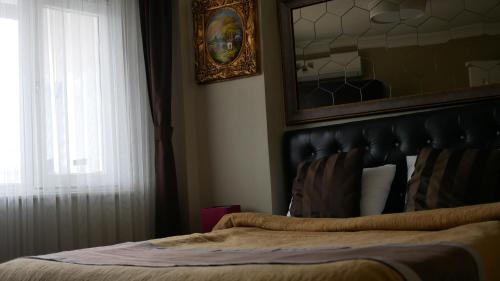 a bedroom with a bed with a mirror and a window at Lena Central Flats in Bursa