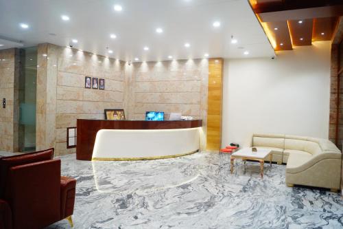 a lobby with a reception desk and a couch at Hotel Shree Shyam International in Bilāspur