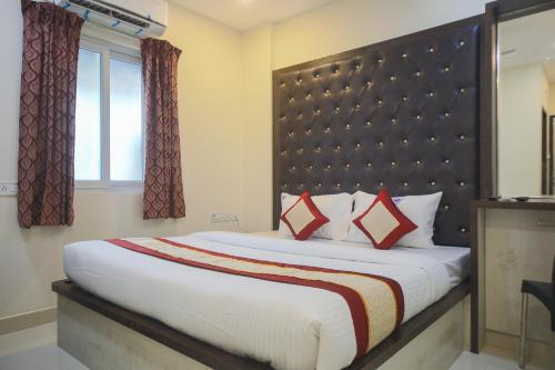 a bedroom with a large bed with a large headboard at Balaji residency in Chennai