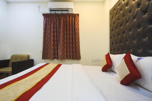 a bedroom with a large bed with red and yellow pillows at Balaji residency in Chennai