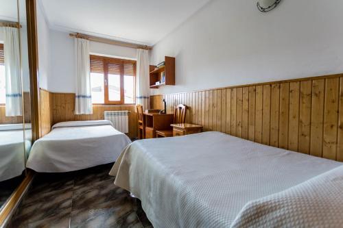 La Rinconada de la SierraにあるHoliday Home Salvaのベッド2台と窓が備わるホテルルームです。