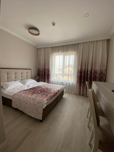 a bedroom with a bed and a large window at Pensiunea Agroturistica Marco in Dumbrăviţa