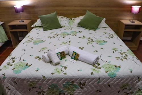 a bed with greenpillows and towels on it at Mediterráneo Suites in Puerto Iguazú