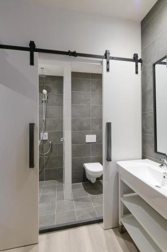 ein Badezimmer mit Dusche, Toilette und Waschbecken in der Unterkunft Hotel De Rustende Jager in Nieuw-Vennep
