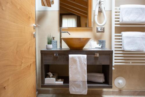 bagno con lavabo a ciotola e specchio di Chalet Tovel - Mountain Lake a Tuenno