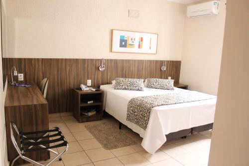 a bedroom with a bed and a wooden wall at Hotel Riviera in Sao Jose do Rio Preto