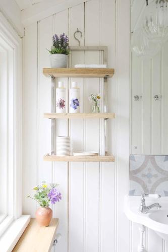 a bathroom with wooden shelves and a sink at Westfield House Farm in Rothbury