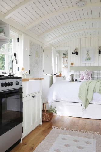 a white bedroom with a bed and a kitchen at Westfield House Farm in Rothbury