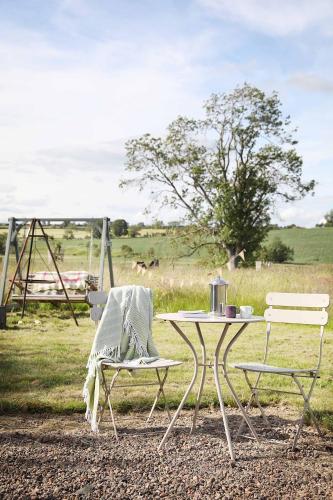 a table and two chairs with a table and a tree at Westfield House Farm in Rothbury