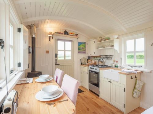 a kitchen with a table and chairs and a stove at Westfield House Farm in Rothbury