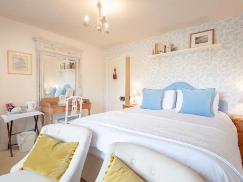 a bedroom with a large bed with blue pillows at Westfield House Farm in Rothbury