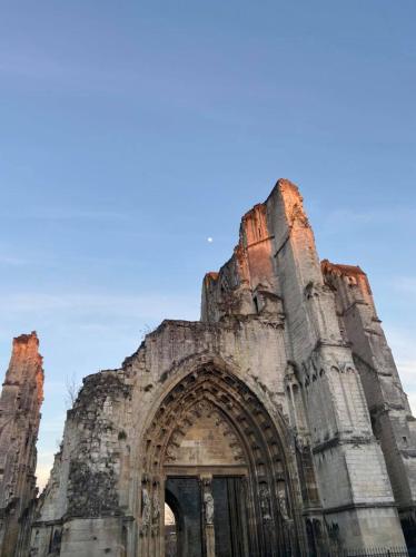 an old stone building with a blue sky in the background at Mercure Saint Omer Centre Gare in Saint-Omer