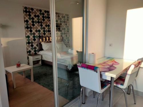 a room with a table and a bed and a mirror at DC Ghencea 158 Self Check-in in Bucharest
