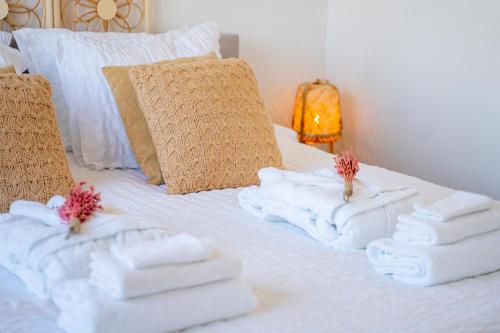 a bed with folded towels on top of it at Nora Waterview in Breda