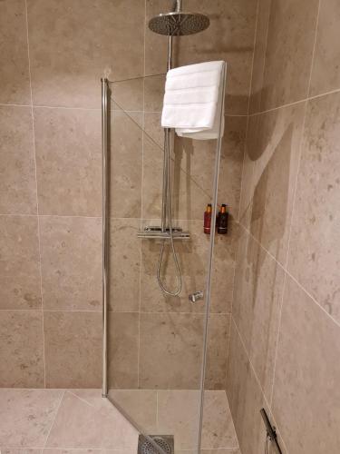 a shower with a glass door with a towel in it at Hotell Viktors in Sälen