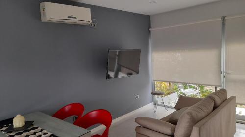 a living room with a couch and a tv on the wall at dolce casa 2 in San Clemente del Tuyú