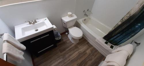 een badkamer met een toilet, een wastafel en een bad bij Super Nights Inn in Sault Ste. Marie