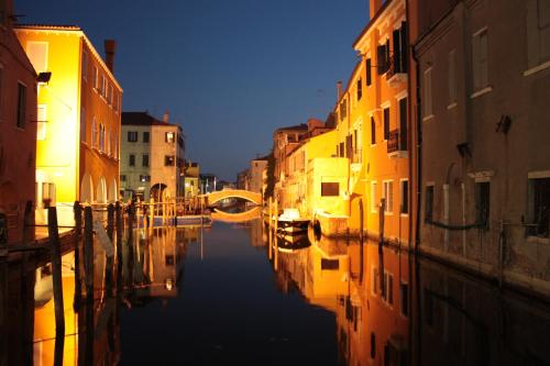 a view of a canal in a city at night at Hotel Europeo in Sottomarina