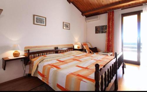 a bedroom with a large bed and a large window at Amphora Deluxe in Vrboska
