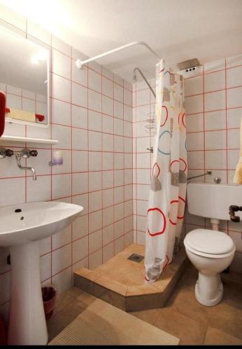 a bathroom with a toilet and a sink and a shower curtain at Amphora Deluxe in Vrboska