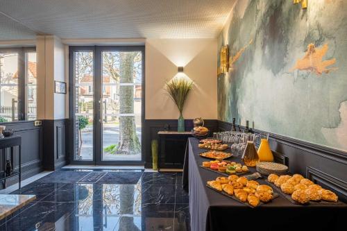 - un buffet avec de la nourriture sur les tables dans la chambre dans l'établissement Mijo's Appartements Hôtel, à Fontenay-sous-Bois