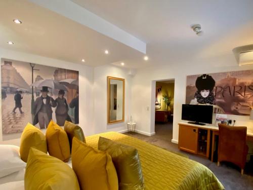 a bedroom with a yellow bed and a tv at Parkhotel Bielefeld in Bielefeld