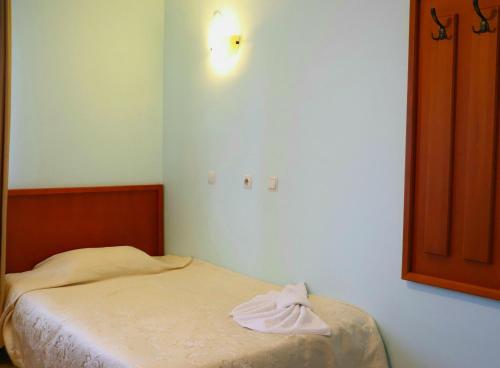 a bedroom with a bed with a towel on it at Family Hotel LILI in Bansko
