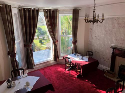 a dining room with a table and a large window at The Brandize Guest House in Torquay