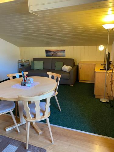 a living room with a table and a couch at Ferienwohnungen Marchanger in Niederau