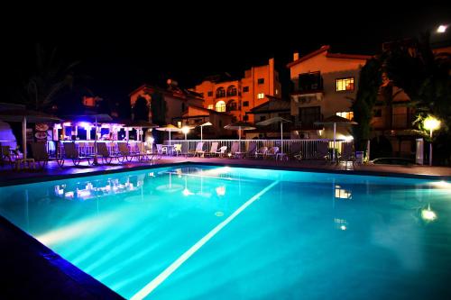 a large swimming pool at night with blue lights at Windmills Hotel Apartments in Protaras