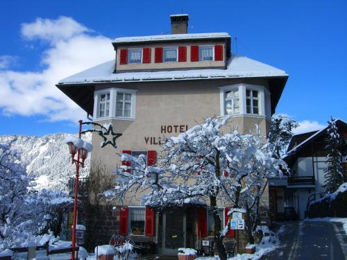 a hotel building with a snow covered roof at Hotel Villa Emilia in Ortisei