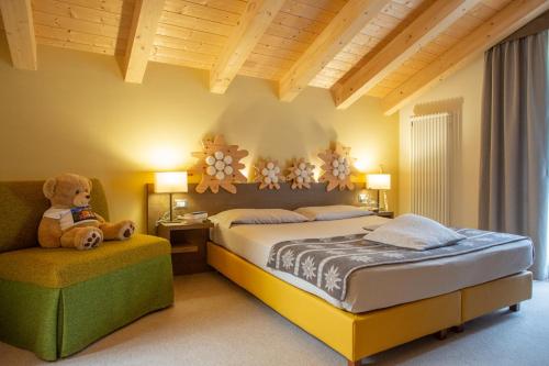 1 dormitorio con 1 cama y 1 osito de peluche en una silla en Chalet Tovel - Mountain Lake, en Tuenno