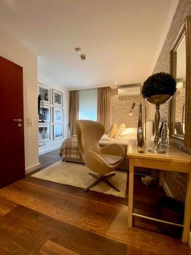 a room with a chair and a desk and a bed at Parkhotel Bielefeld in Bielefeld