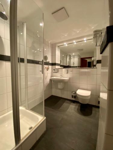a bathroom with a toilet and a sink and a shower at Parkhotel Bielefeld in Bielefeld