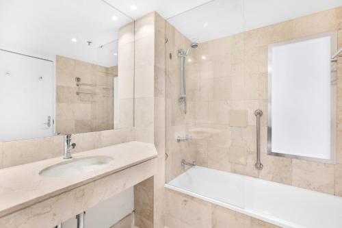 W łazience znajduje się umywalka i prysznic. w obiekcie Ocean-View Studio Near Beach with Rooftop Jacuzzis w mieście Gold Coast