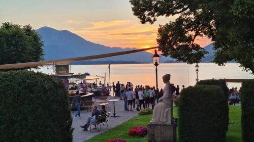 a crowd of people walking around a park at sunset at Apartementhaus Schöndorfer in Strobl